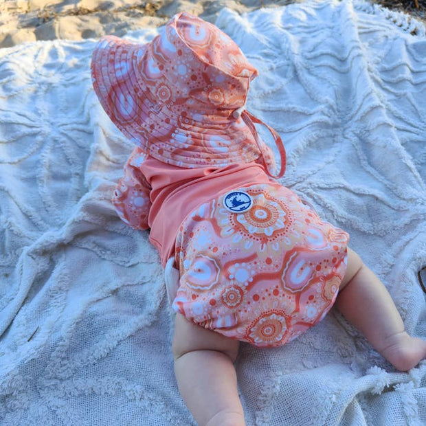 Reusable swim nappy with matching waterproof mini wet bag in Community Connected to Land print