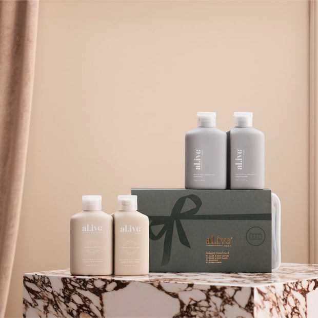 al.ive body Holiday Hair & Body Travel Pack displayed with four travel-sized bottles and green gift-style travel bag.
