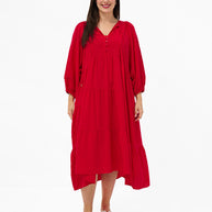 Model wearing the Mata Dress in Red featuring a tiered skirt, 3/4 sleeves and a relaxed oversized fit.