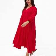 Model wearing the Mata Dress in Red featuring a tiered skirt, 3/4 sleeves and a relaxed oversized fit.