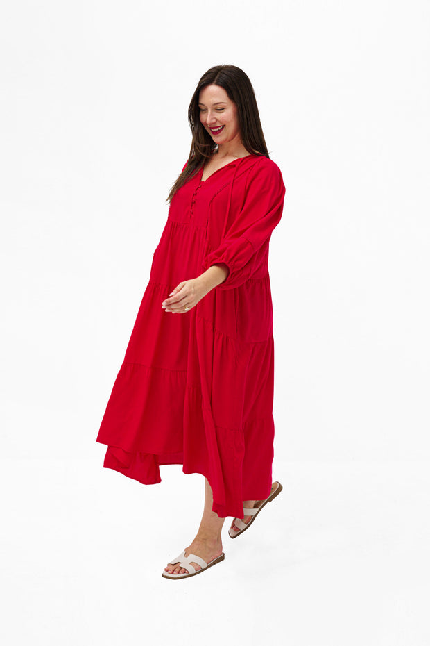 Model wearing the Mata Dress in Red featuring a tiered skirt, 3/4 sleeves and a relaxed oversized fit.