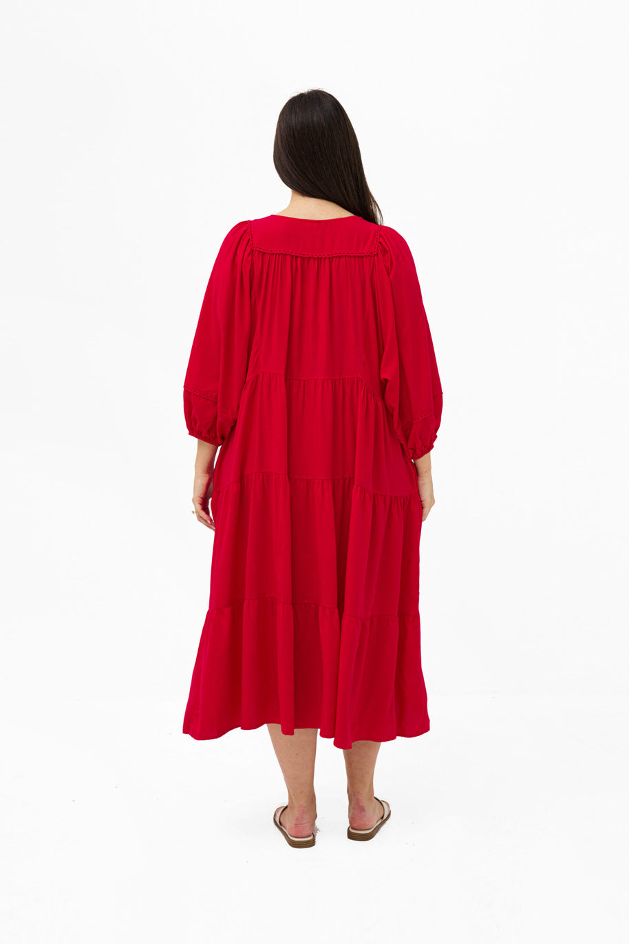 Model wearing the Mata Dress in Red featuring a tiered skirt, 3/4 sleeves and a relaxed oversized fit.