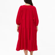 Model wearing the Mata Dress in Red featuring a tiered skirt, 3/4 sleeves and a relaxed oversized fit.