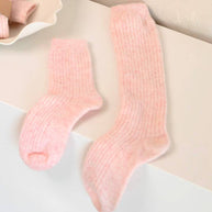 Bed and Butter cosy blush pink knee high socks styled against a clean white background