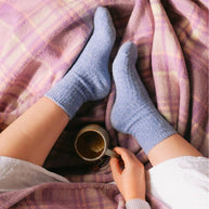 Bed and Butter cosy lavender ankle socks resting on waffle blanket