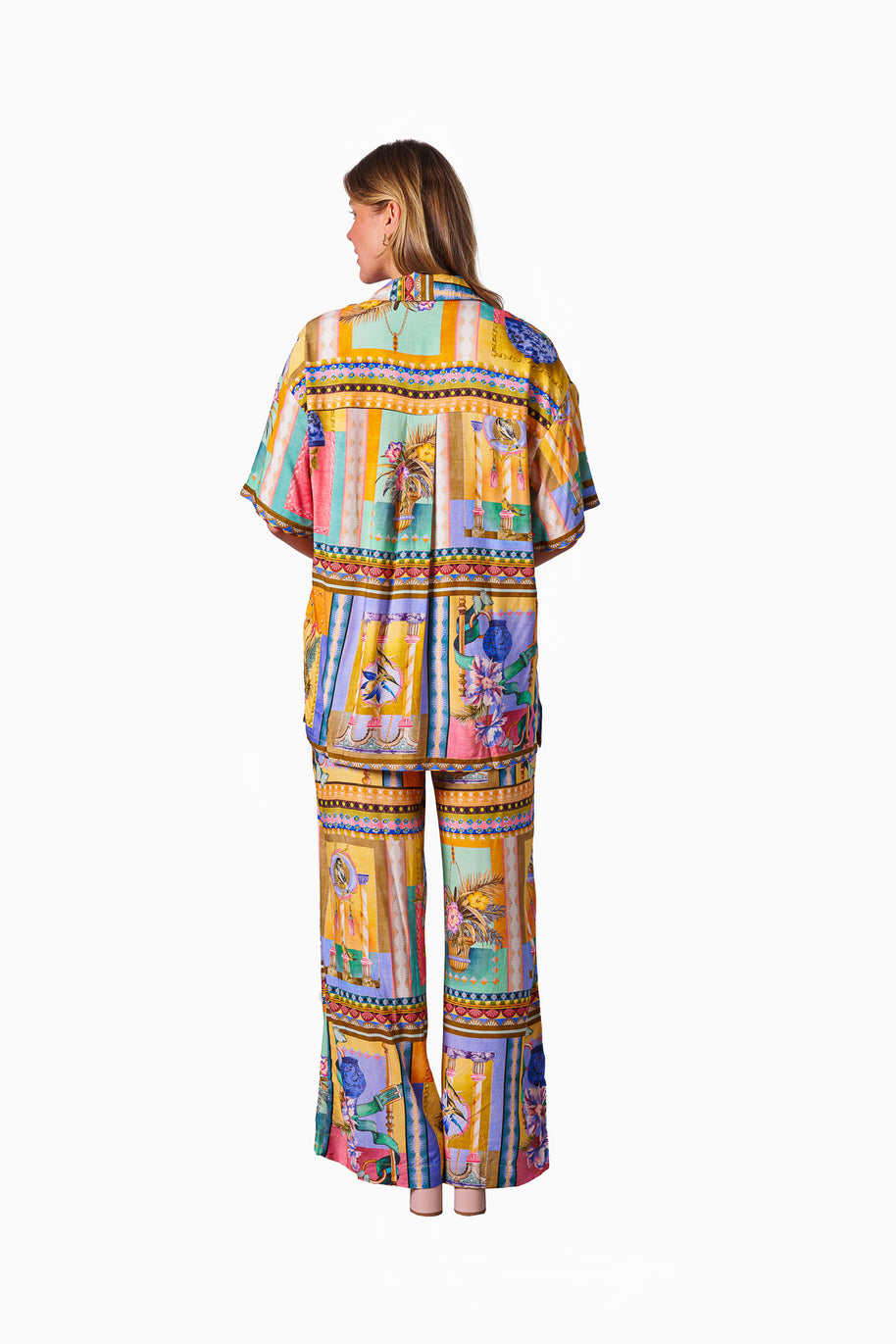 Model wearing the Kaena Pants in Multi Print featuring a straight leg, elastic waist, drawstring and bold patch-style print
