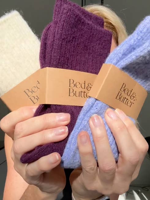 Deep wine coloured cosy socks folded in a stack with other colours
