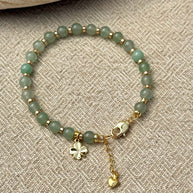 Green jade beaded bracelet with four leaf clover charm
