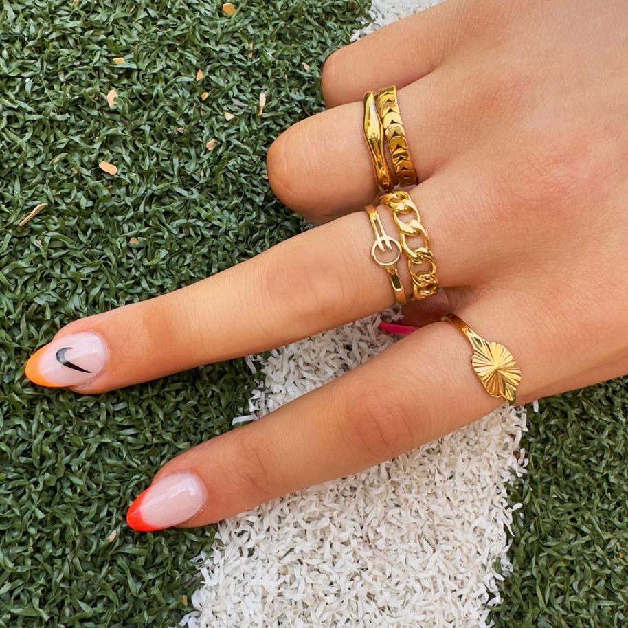 Gold stacking ring worn on a finger with other rings