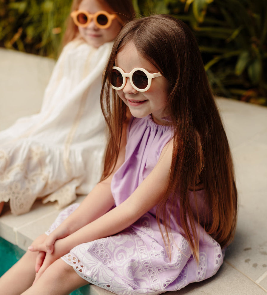 Neutral bone-coloured children’s sunglasses with round acrylic lenses