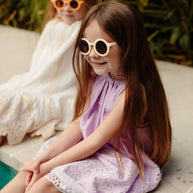 Neutral bone-coloured children’s sunglasses with round acrylic lenses