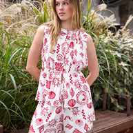 Model wearing the Hess Top in white and red with a gathered bodice and flouncy hem.