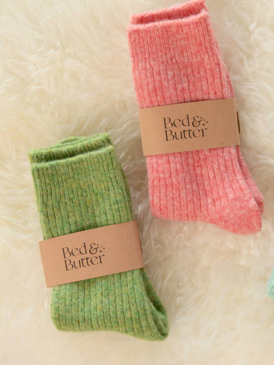 Soft light red cashmere wool blend socks worn while relaxing on a cosy sofa