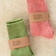 Soft light red cashmere wool blend socks worn while relaxing on a cosy sofa