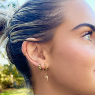 Small gold hoop earrings layered in an ear stack