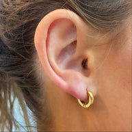 EVER Trackside gold huggie earrings worn on an ear