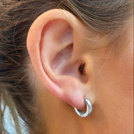 EVER Trackside silver huggie earrings worn on an ear