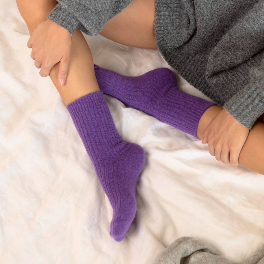 Vibrant royal purple cosy socks being put on while relaxing