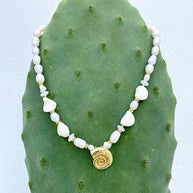 White gemstone and freshwater pearl beaded necklace with gold spiral shell centrepiece