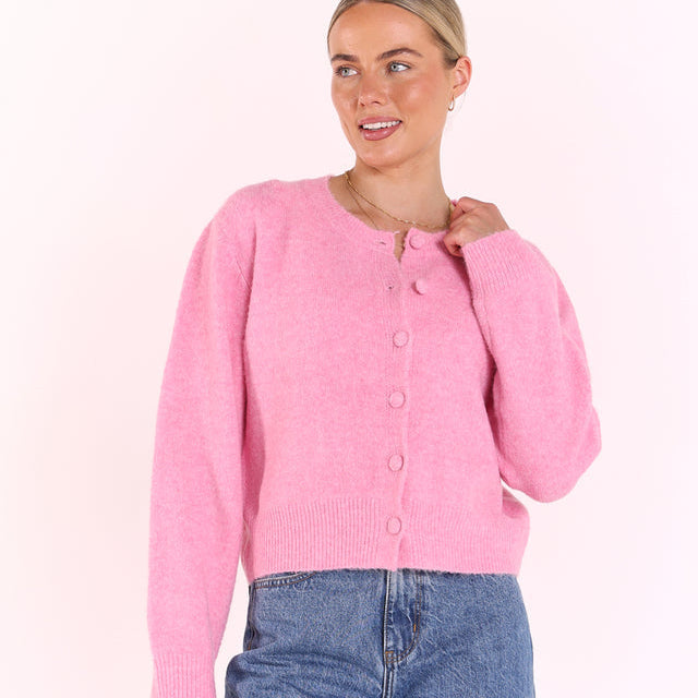 Woman wearing pink button down knit cardigan with ribbed hem