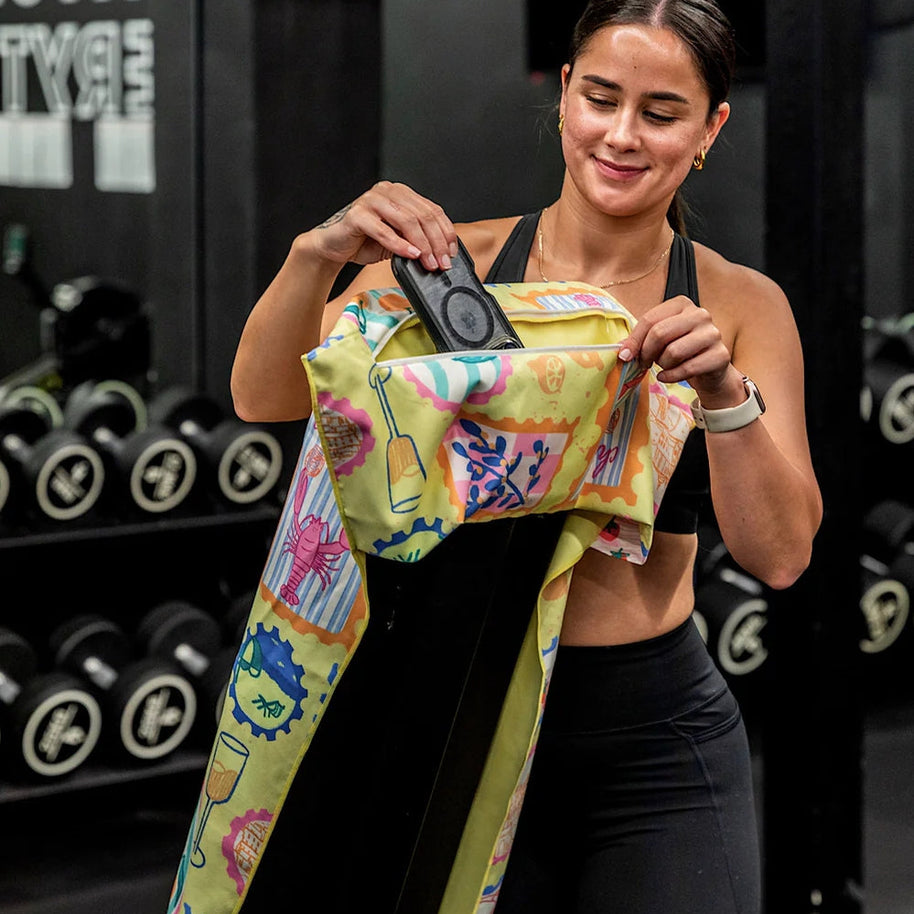 Yellow postcard print towel hooked over gym bench