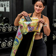 Yellow postcard print towel hooked over gym bench