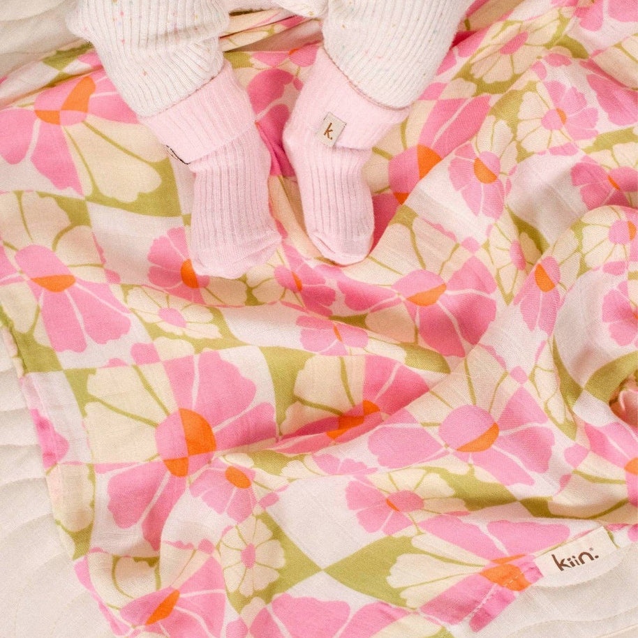 Baby swaddle in Whimsy print with pink, olive and orange florals