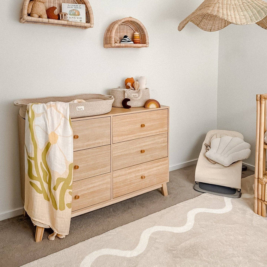 Baby swaddle with ivory petal print on warm oat background