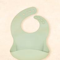 Kiin Baby Silicone Bib in Blossom – pink silicone feeding bib with adjustable neck and deep catch pocket.