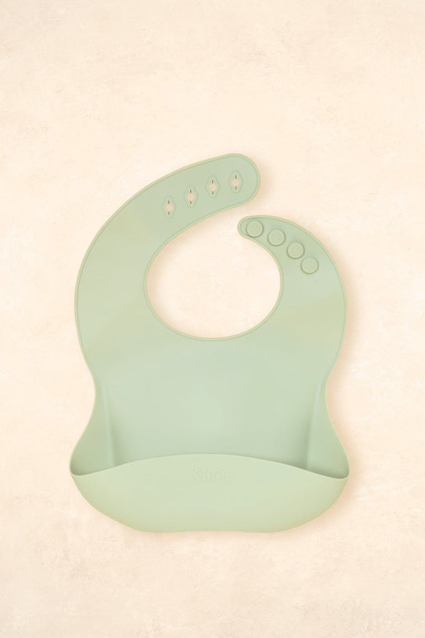 Kiin Baby Silicone Bib in Blossom – pink silicone feeding bib with adjustable neck and deep catch pocket.