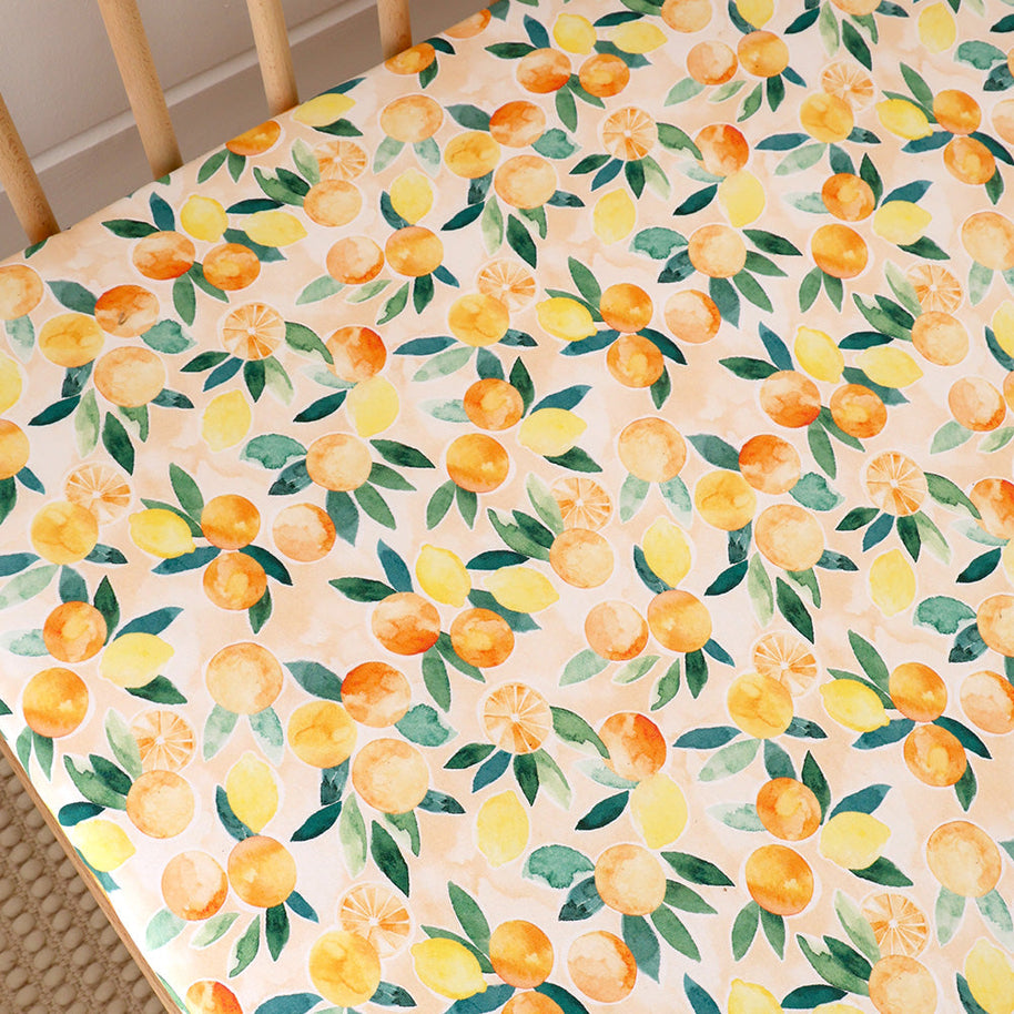 Soft organic cotton cot sheet in bright citrus fruit print